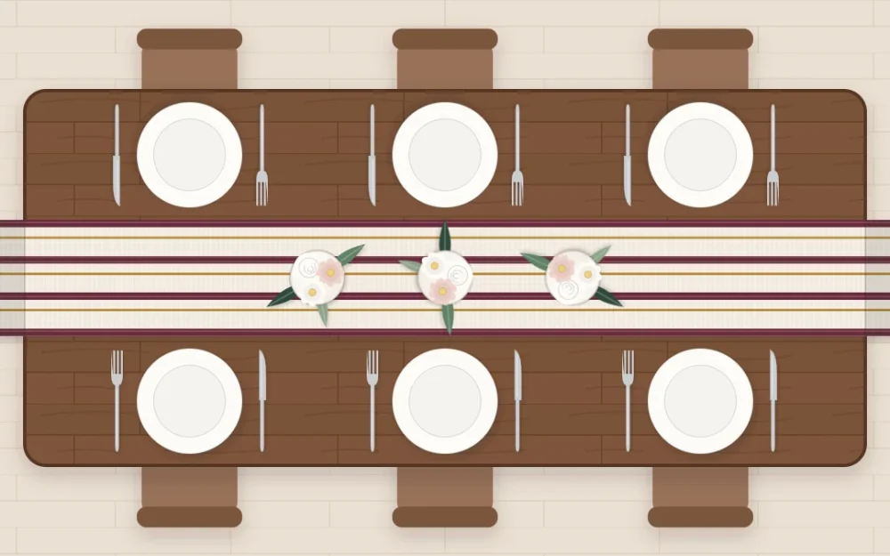 Top-down view of a long walnut table with a striped linen runner hanging over both ends, three small vases and six plates