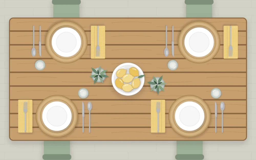 Top-down outdoor wooden slat table set for four with woven placemats, white plates, yellow napkins, a bowl of lemon shapes and jars of herbs