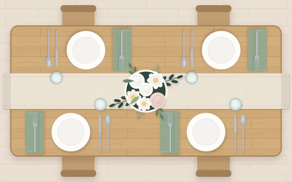 Top-down view of an oak table set for four with a linen runner, a low vase of white flowers, ivory plates and sage napkins